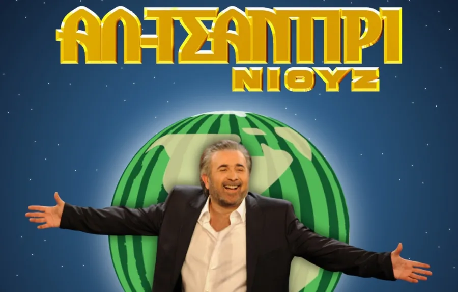 Ο Λάκης Λαζόπουλος μπροστά από το λογότυπο της εκπομπής Αλ Τσαντίρι Νιουζ.