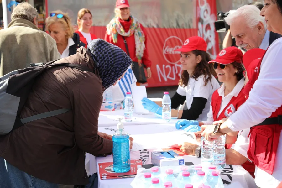 Εθελοντές του Ελληνικού Ερυθρού Σταυρού προσφέρουν βοήθεια σε πολίτες στο κέντρο της Αθήνας.