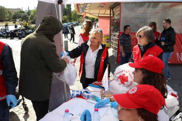 Εθελοντές του Ελληνικού Ερυθρού Σταυρού μοιράζουν ανθρωπιστική βοήθεια σε άστεγο στο κέντρο της Αθήνας.