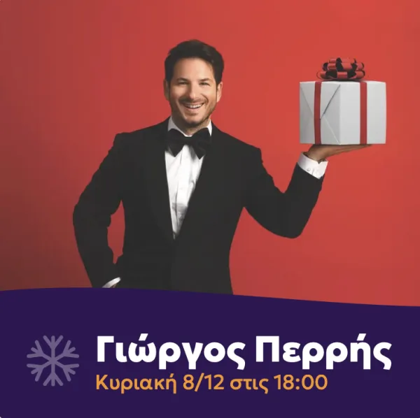 Ο Γιώργος Περρής με σμόκιν κρατάει ένα χριστουγεννιάτικο δώρο σε κόκκινο φόντο.