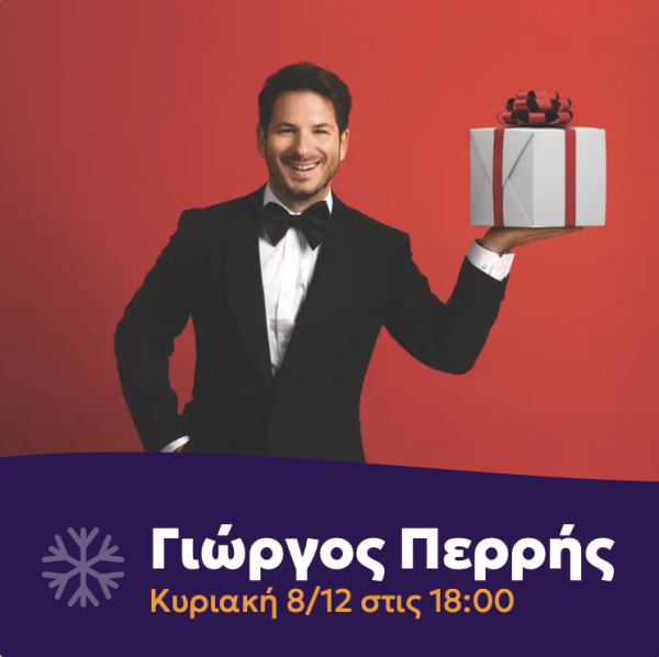 Ο Γιώργος Περρής με σμόκιν κρατάει ένα χριστουγεννιάτικο δώρο σε κόκκινο φόντο.