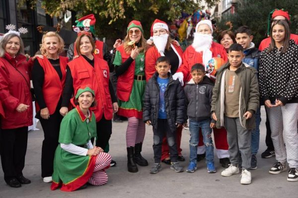 Εθελοντές του Ελληνικού Ερυθρού Σταυρού με παιδιά σε εορταστική εκδήλωση.