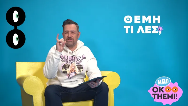 Ο Θέμης Γεωργαντάς κάθεται σε κίτρινη πολυθρόνα σε μπλε φόντο.