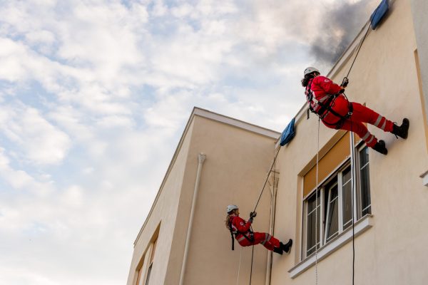 Εθελοντές του Ελληνικού Ερυθρού Σταυρού πραγματοποιούν κατάβαση με σχοινιά σε κτίριο.