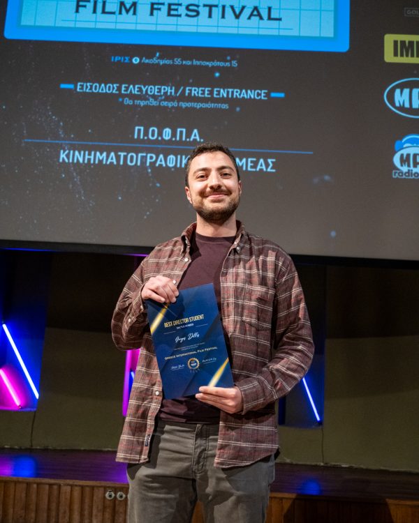 Ένας άνδρας κρατάει βραβείο Best Director Student στο 5ο Greece International Film Festival.