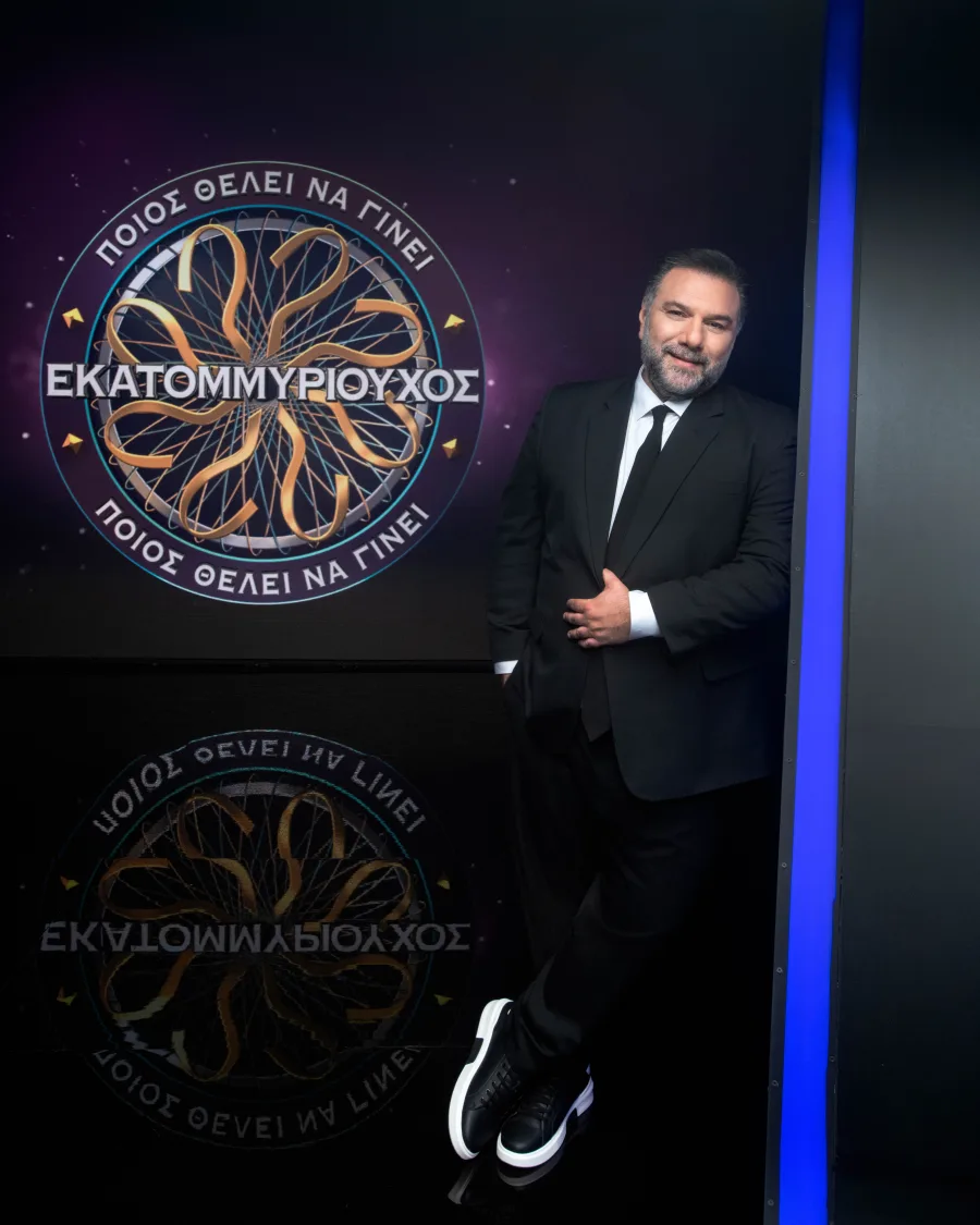 Ο παρουσιαστής Γρηγόρης Αρναούτογλου με το λογότυπο του τηλεπαιχνιδιού "Ποιος θέλει να γίνει εκατομμυριούχος" για τα τηλεπαιχνίδια 2025-2026.