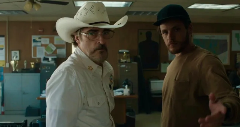 Ο Joaquin Phoenix με καουμπόικο καπέλο και ένας άνδρας με τζόκεϊ στην ταινία Eddington.