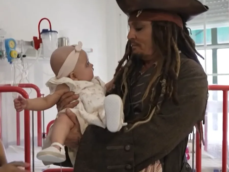 Ο Johnny Depp ως Jack Sparrow κρατάει ένα μωρό σε νοσοκομείο.