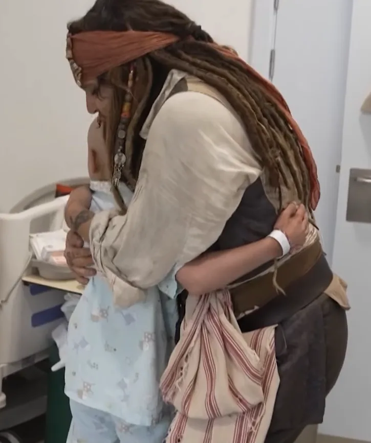 Ο Johnny Depp ως Jack Sparrow αγκαλιάζει ένα παιδί σε νοσοκομείο.