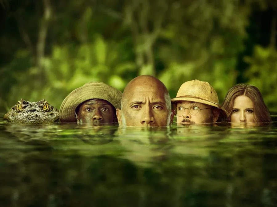 Πρωταγωνιστές της ταινίας Jumanji μέσα στο νερό δίπλα σε κροκόδειλο.