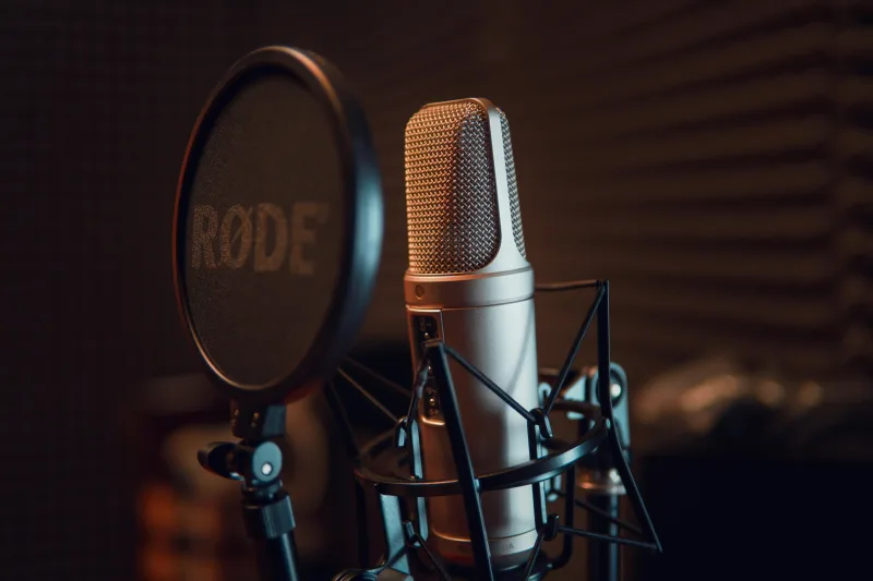 Επαγγελματικό μικρόφωνο πυκνωτή με pop filter σε ραδιοφωνικό στούντιο.