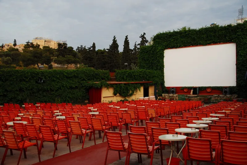 Άποψη του θερινού κινηματογράφου Σινέ Θησείο με θέα την Ακρόπολη κάτω από τον καλοκαιρινό νυχτερινό ουρανό.