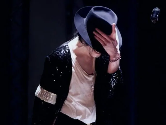 Ο Michael Jackson στη σκηνή με μαύρο σακάκι με παγιέτες και καπέλο.