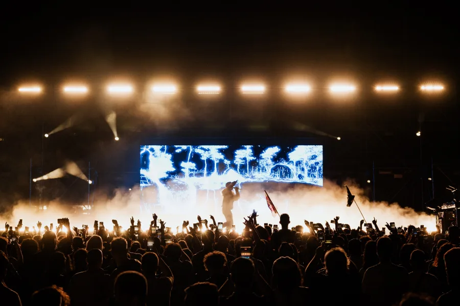 Καλλιτέχνης στη σκηνή του Plisskën Festival μπροστά σε πλήθος.