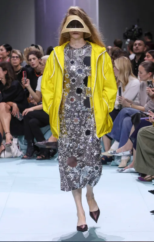 Μοντέλο του οίκου Prada με look από τη συλλογή Wrong jacket theory που συνδυάζει βραδινό ένδυμα με streetwear.