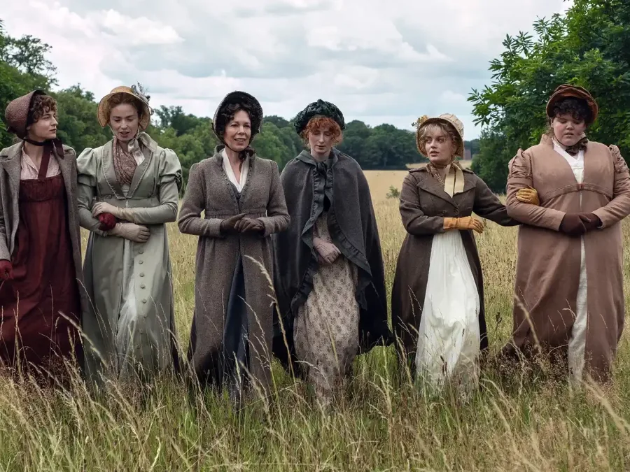 Ηθοποιοί από το «Pride and Prejudice» του Netflix στέκονται μαζί σε ένα χωράφι με ψηλό χορτάρι.