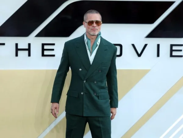 Ο Brad Pitt με κομψό πράσινο κοστούμι ποζάρει μπροστά από το λογότυπο της νέας του ταινίας, μετά τα γυρίσματα στην Ύδρα.