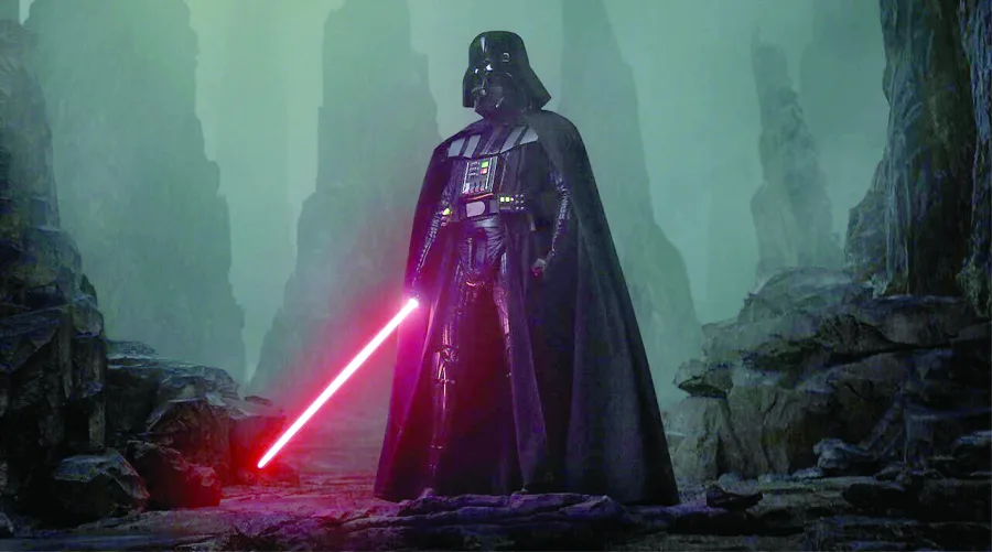 Ο Darth Vader με το κόκκινο φωτόσπαθό του σε ένα ομιχλώδες, βραχώδες τοπίο.