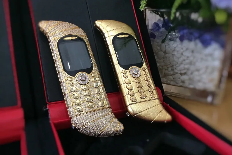 Δύο χρυσά smartphones διακοσμημένα με διαμάντια, αντιπροσωπεύουν την πολυτέλεια και την τεχνολογία στα ακριβότερα κινητά τηλέφωνα.