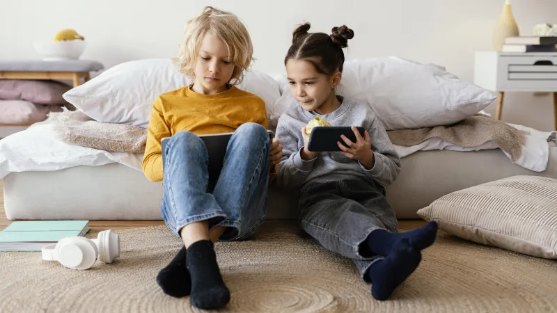 Παιδί που χρησιμοποιεί tablet ή smartphone, εστιάζοντας στην επίδραση των οθονών στην υγεία του εγκεφάλου.
