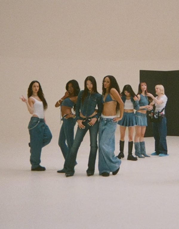 Το συγκρότημα KATSEYE ποζάρει με denim σύνολα σε λευκό φόντο.