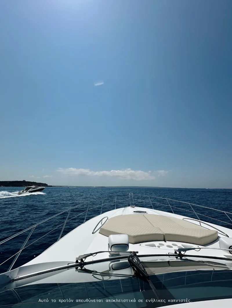 Άποψη από την πλώρη ενός σκάφους που πλέει στη θάλασσα κάτω από τον γαλάζιο ουρανό.