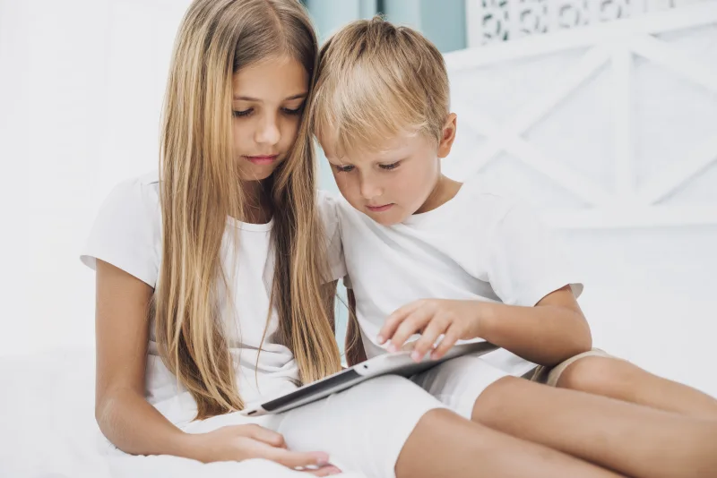 Παιδί που χρησιμοποιεί tablet ή smartphone, εστιάζοντας στην επίδραση των οθονών στην υγεία του εγκεφάλου.