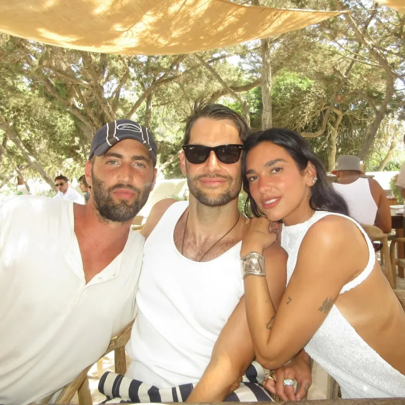 Η Dua Lipa με δύο άνδρες σε εξωτερικό χώρο.