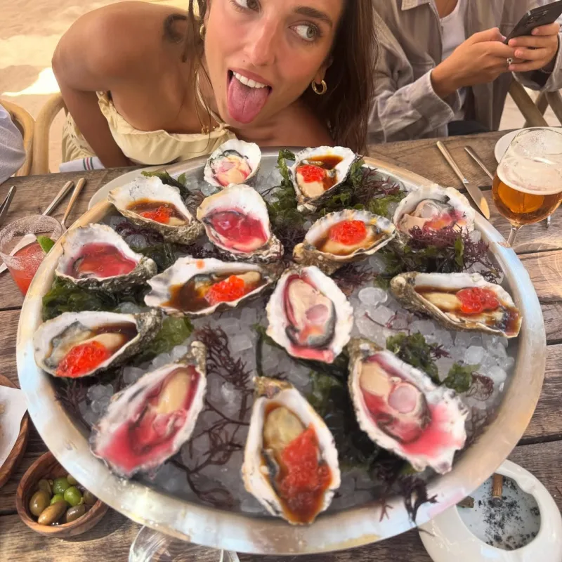 Η Dua Lipa ποζάρει πίσω από μια πιατέλα με στρείδια.