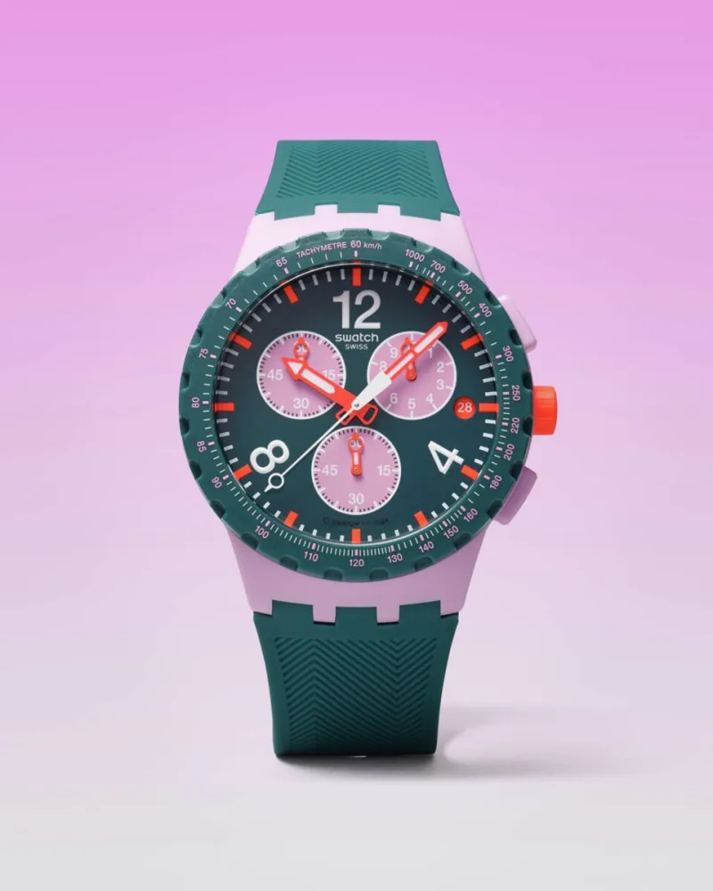 Ρολόι Swatch Essentials σε πράσινο και ροζ χρώμα με πορτοκαλί λεπτομέρειες.