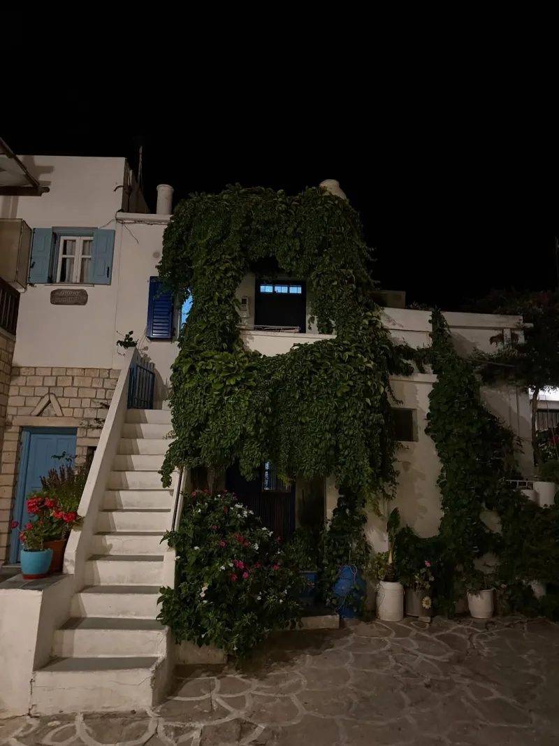 Παραδοσιακό λευκό σπίτι στην Κίμωλο με αναρριχώμενα φυτά τη νύχτα.