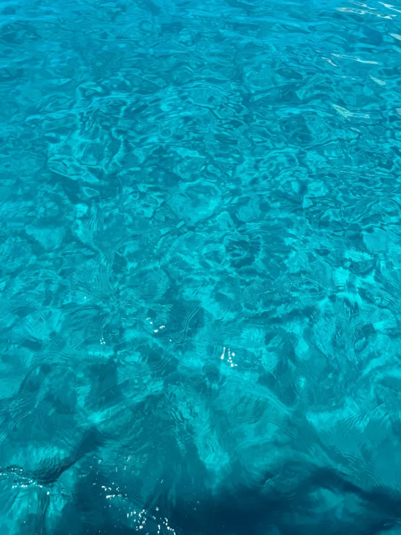 Κοντινό πλάνο σε καταγάλανα, κρυστάλλινα νερά της θάλασσας με κυματισμούς.
