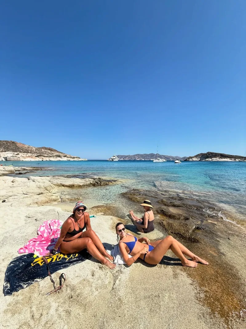 Η Τόνια Σωτηροπούλου με φίλες της σε βραχώδη παραλία στην Κίμωλο.