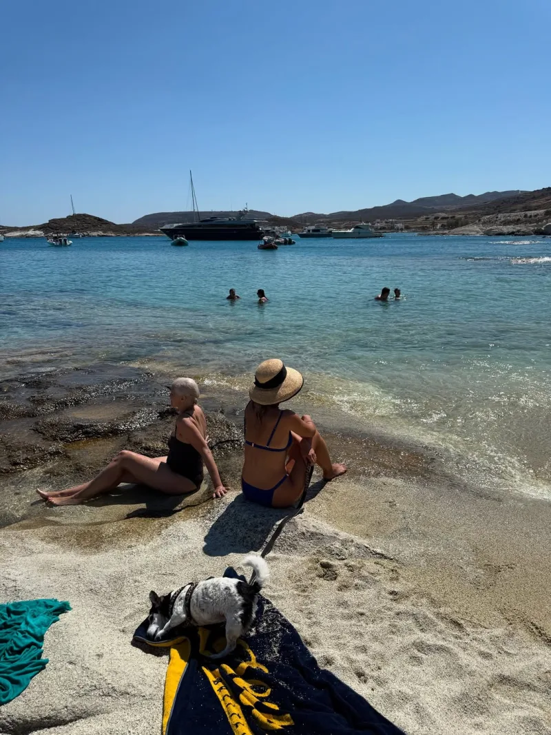 Η Τόνια Σωτηροπούλου κάθεται σε βράχια δίπλα στη θάλασσα στην Κίμωλο.
