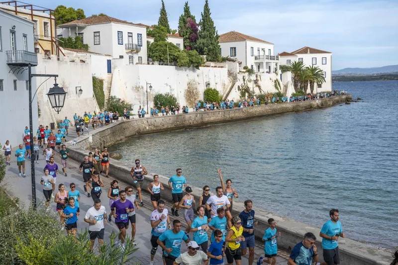Πλήθος κόσμου συμμετέχει στο Spetses Mini Marathon δίπλα στη θάλασσα.