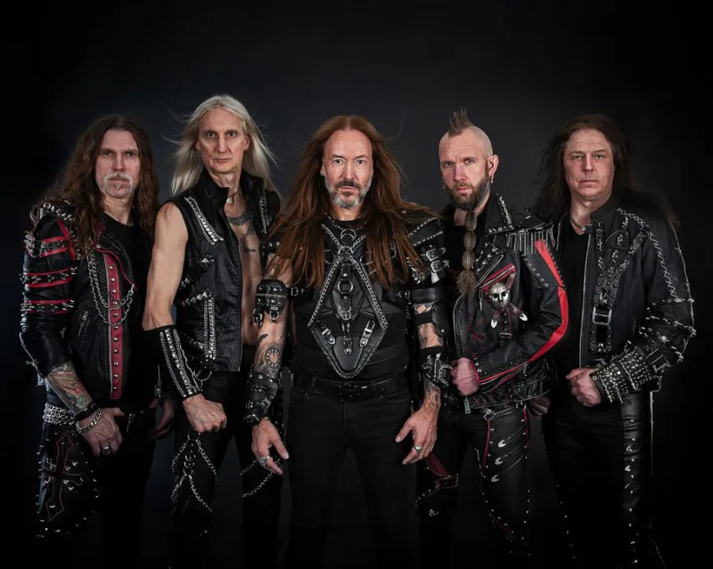 Πενταμελές heavy metal συγκρότημα με δερμάτινα ρούχα και αλυσίδες.