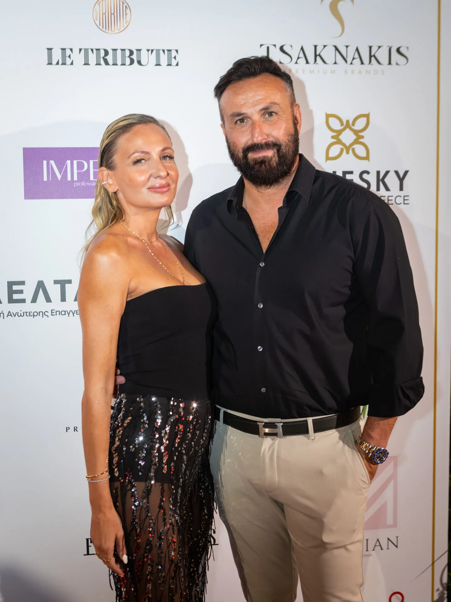 Ένας άνδρας και μια γυναίκα ποζάρουν σε εκδήλωση του Εκπαιδευτικού Ομίλου ΔΕΛΤΑ 360.