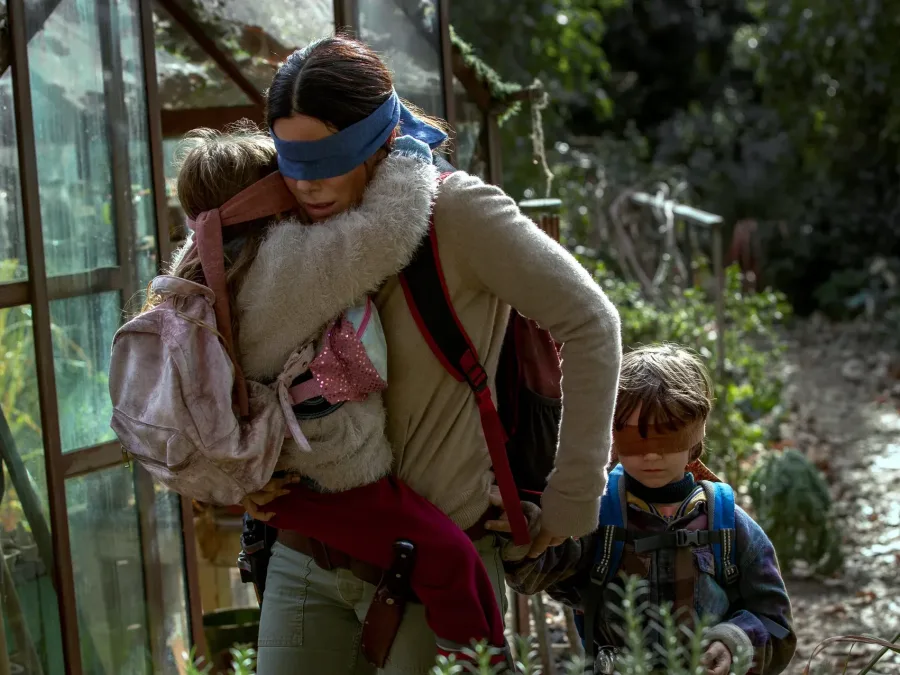 Σκηνή από την ταινία Bird Box με τη Sandra Bullock και δύο παιδιά να φορούν μαντήλια στα μάτια.