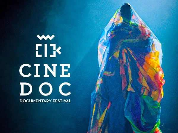 Αφίσα του CineDoc Documentary Festival με φιγούρα καλυμμένη με πολύχρωμο ύφασμα.