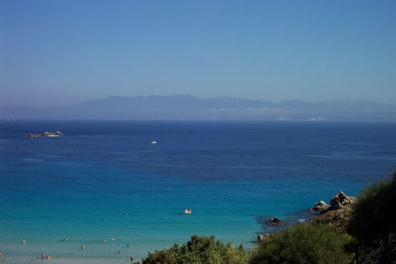 Πανοραμική θέα παραδοσιακού χωριού στη Σαρδηνία με πέτρινα σπίτια και καταπράσινο τοπίο.