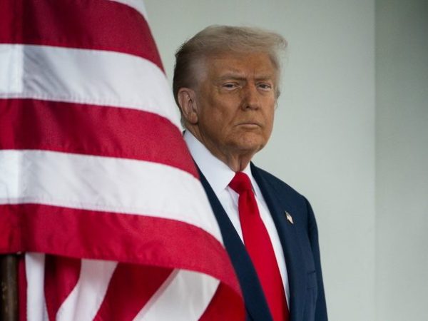 Ο Donald Trump στέκεται δίπλα στην αμερικανική σημαία, με φόντο το Super Bowl 2026.