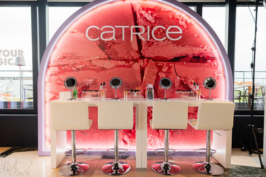 Beauty corner της CATRICE με λευκά σκαμπό και καθρέφτες μακιγιάζ.