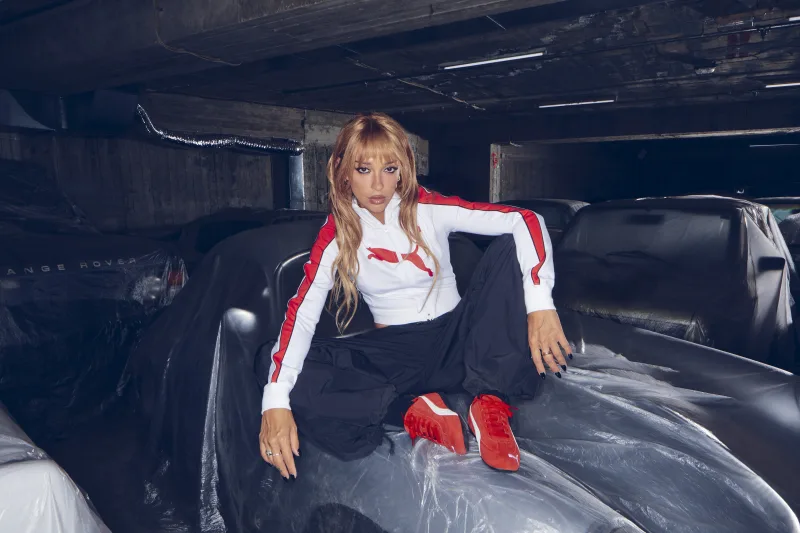 Η Ελένη Φουρέιρα ποζάρει με αθλητικά ρούχα Puma πάνω σε καλυμμένα αυτοκίνητα.