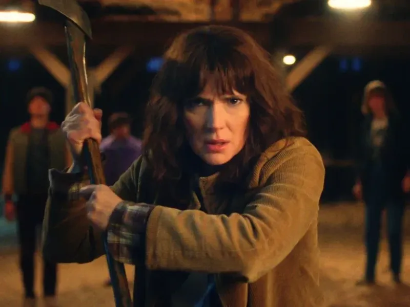 Σκηνή από τη σειρά Stranger Things με γυναίκα που κρατά τσεκούρι.