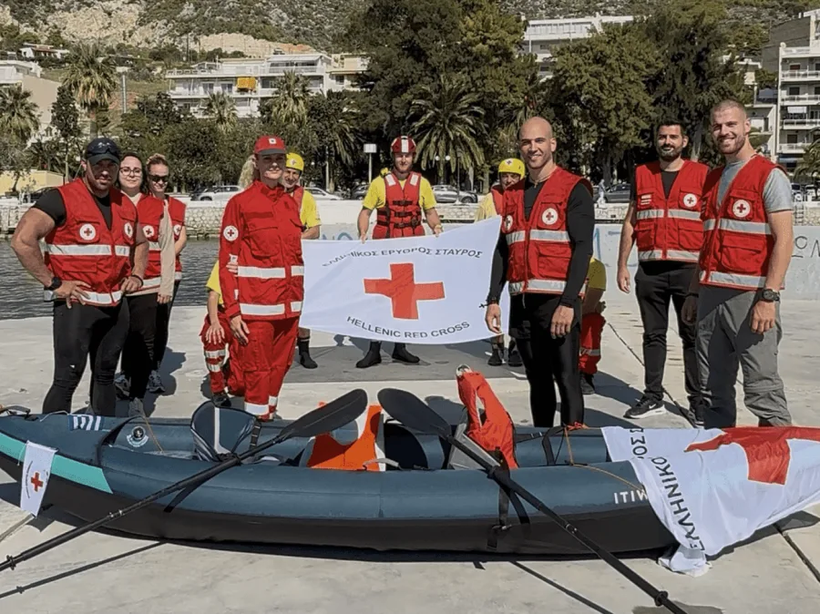 Ο Σωτήρης Μπαρμπαρόσος και μέλη του Ελληνικού Ερυθρού Σταυρού με καγιάκ και σημαία.