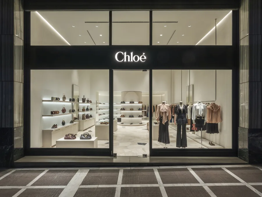Η πρόσοψη της νέας μπουτίκ Chloé στην Αθήνα με φωτισμένες βιτρίνες.