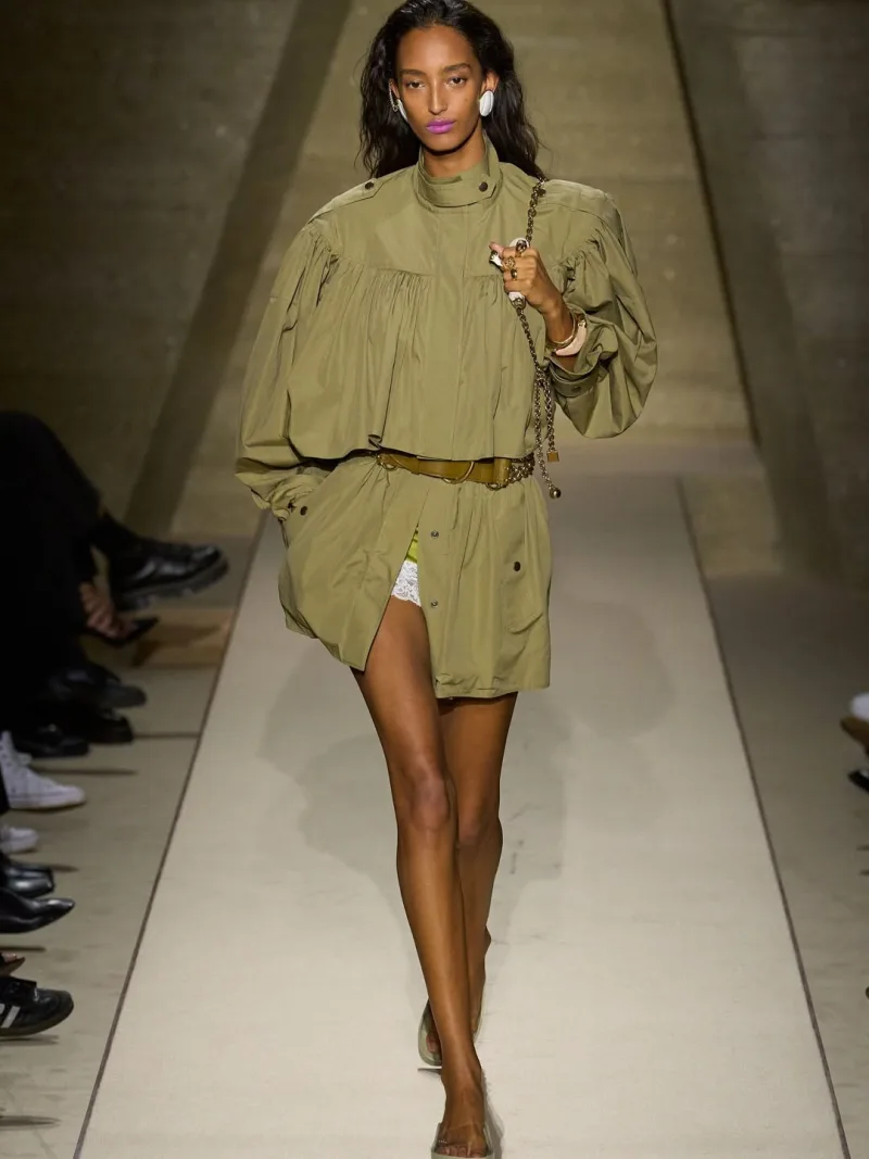 Μοντέλο στην επίδειξη Chloé SS26 με λαδί σύνολο και ζώνη.