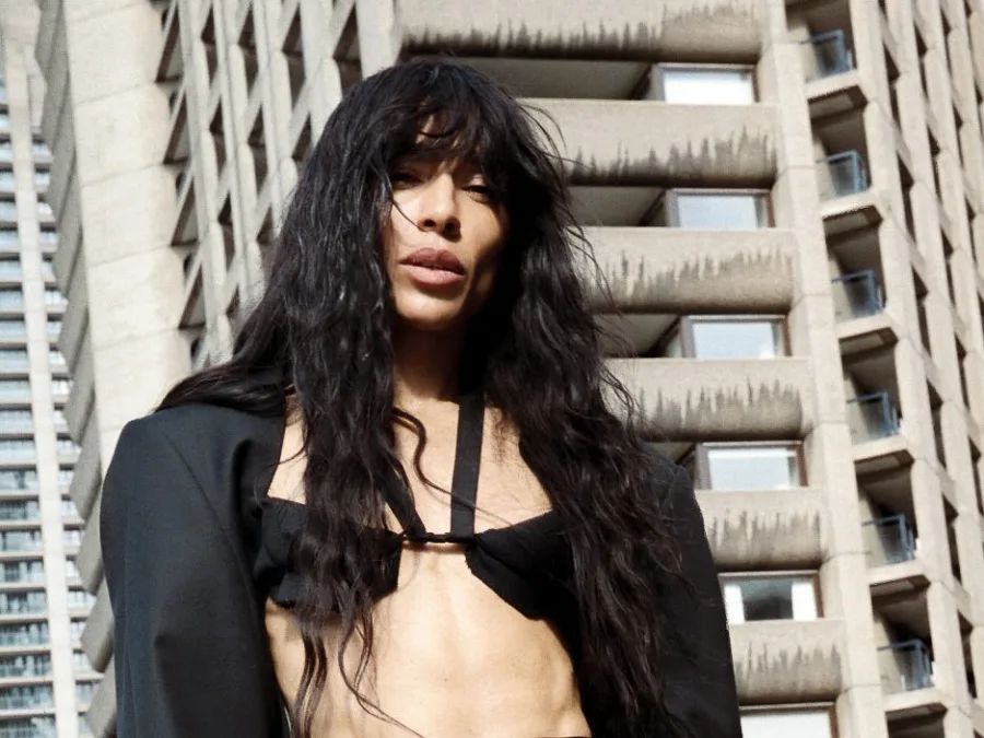 Η Loreen με μαύρο σακάκι και crop top μπροστά από κτίριο.