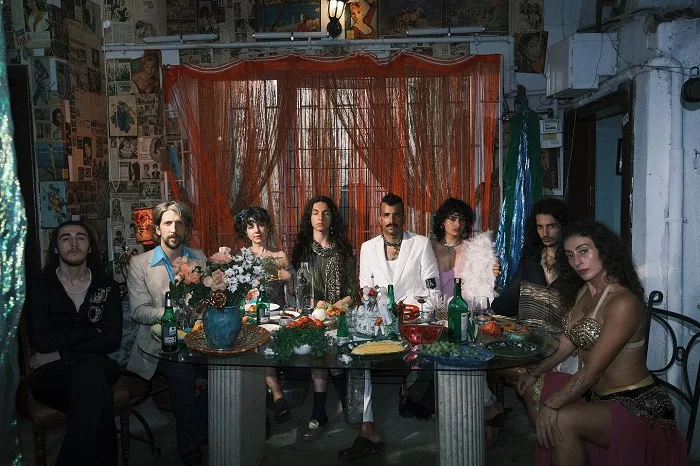 Το συγκρότημα Seven of Hearts σε ένα τραπέζι με art-pop αισθητική.