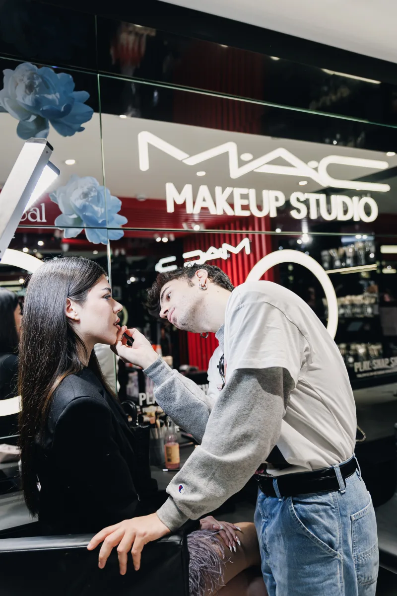 Makeup artist εφαρμόζει κραγιόν σε γυναίκα σε κατάστημα MAC Cosmetics.